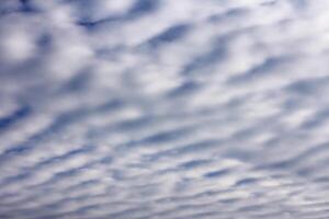 sky with layered cumulus clouds. blue background with unusual cloud texture photo