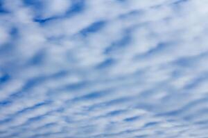 sky with layered cumulus clouds. blue background with unusual cloud texture photo
