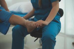 Physical therapists work with patients in close-up clinics. The concept of rehabilitation of physical health, the doctor gives advice to the patient. Ankle problems and muscle injuries photo