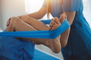 Physical therapists work with patients in close-up clinics. The concept of rehabilitation of physical health, the doctor gives advice to the patient. Ankle problems and muscle injuries photo