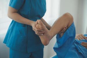 Physical therapists work with patients in close-up clinics. The concept of rehabilitation of physical health, the doctor gives advice to the patient. Ankle problems and muscle injuries photo