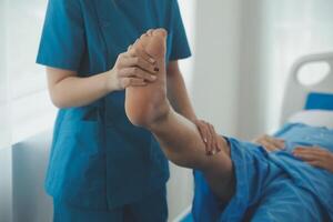 Physical therapists work with patients in close-up clinics. The concept of rehabilitation of physical health, the doctor gives advice to the patient. Ankle problems and muscle injuries photo