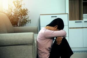 Depressed woman sitting alone on the bed with hands on head feel stress, sad and worried in the dark bedroom and low light environment photo