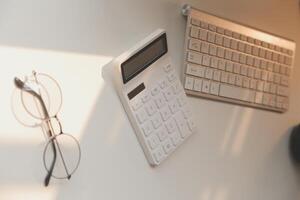 Desk with laptop, eye glasses, earphone, pen and a cup of coffee. Top view with copy space. photo