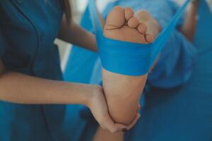 Physical therapists work with patients in close-up clinics. The concept of rehabilitation of physical health, the doctor gives advice to the patient. Ankle problems and muscle injuries photo
