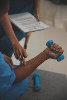 Professional physical therapist examines and cares for a young man in a physical therapy center, treating muscles and injuries of a man in a hospital. photo