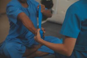 Professional physical therapist examines and cares for a young man in a physical therapy center, treating muscles and injuries of a man in a hospital. photo