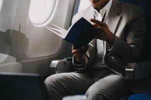Airplane, travel and portrait of businessman working on laptop computer and smartphone while sitting in airplane. photo