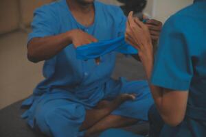 Professional physical therapist examines and cares for a young man in a physical therapy center, treating muscles and injuries of a man in a hospital. photo