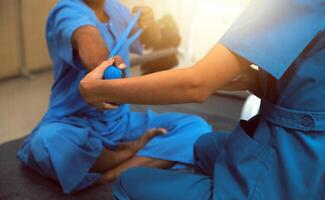 Professional physical therapist examines and cares for a young man in a physical therapy center, treating muscles and injuries of a man in a hospital. photo