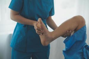 Physical therapists work with patients in close-up clinics. The concept of rehabilitation of physical health, the doctor gives advice to the patient. Ankle problems and muscle injuries photo