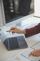 Cropped image of professional businesswoman working at her office via laptop, young female manager using portable computer device while sitting at modern loft, flare light, work process concept photo