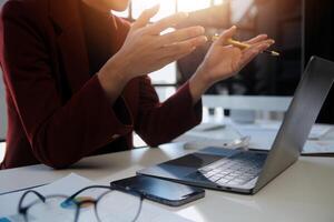 Cropped image of professional businesswoman working at her office via laptop, young female manager using portable computer device while sitting at modern loft, flare light, work process concept photo