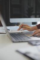 Cropped image of professional businesswoman working at her office via laptop, young female manager using portable computer device while sitting at modern loft, flare light, work process concept photo