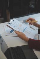 Cropped image of professional businesswoman working at her office via laptop, young female manager using portable computer device while sitting at modern loft, flare light, work process concept photo
