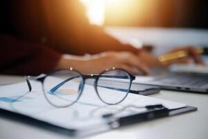 Cropped image of professional businesswoman working at her office via laptop, young female manager using portable computer device while sitting at modern loft, flare light, work process concept photo