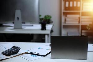 Laptop computer with opened lid on table in meeting room of office workspace. photo