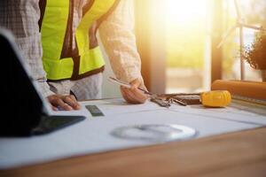 engineer people meeting working and pointing at a blueprint in office for discussing. Engineering tools and construction concept photo