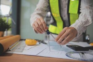 engineer people meeting working and pointing at a blueprint in office for discussing. Engineering tools and construction concept photo