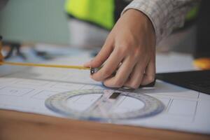 engineer people meeting working and pointing at a blueprint in office for discussing. Engineering tools and construction concept photo
