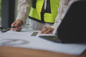 engineer people meeting working and pointing at a blueprint in office for discussing. Engineering tools and construction concept photo