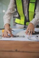 engineer people meeting working and pointing at a blueprint in office for discussing. Engineering tools and construction concept photo