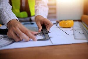 engineer people meeting working and pointing at a blueprint in office for discussing. Engineering tools and construction concept photo