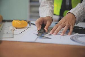 engineer people meeting working and pointing at a blueprint in office for discussing. Engineering tools and construction concept photo