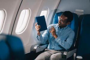 Airplane, travel and portrait of businessman working on laptop computer and smartphone while sitting in airplane. photo