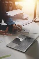 Group of confident business people point to graphs and charts to analyze market data, balance sheet, account, net profit to plan new sales strategies to increase production capacity. photo