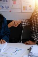 Group of confident business people point to graphs and charts to analyze market data, balance sheet, account, net profit to plan new sales strategies to increase production capacity. photo