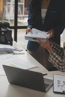 Group of confident business people point to graphs and charts to analyze market data, balance sheet, account, net profit to plan new sales strategies to increase production capacity. photo