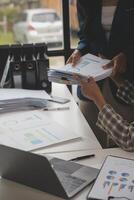 Group of confident business people point to graphs and charts to analyze market data, balance sheet, account, net profit to plan new sales strategies to increase production capacity. photo