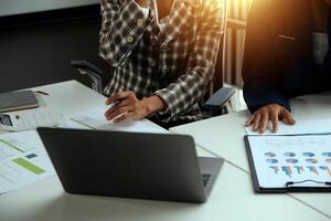 Group of confident business people point to graphs and charts to analyze market data, balance sheet, account, net profit to plan new sales strategies to increase production capacity. photo