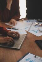 Group of confident business people point to graphs and charts to analyze market data, balance sheet, account, net profit to plan new sales strategies to increase production capacity. photo