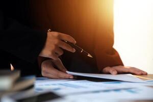 Group of confident business people point to graphs and charts to analyze market data, balance sheet, account, net profit to plan new sales strategies to increase production capacity. photo