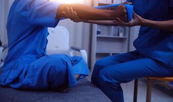 Professional physical therapist examines and cares for a young man in a physical therapy center, treating muscles and injuries of a man in a hospital. photo