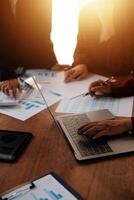 Group of confident business people point to graphs and charts to analyze market data, balance sheet, account, net profit to plan new sales strategies to increase production capacity. photo