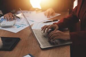 Group of confident business people point to graphs and charts to analyze market data, balance sheet, account, net profit to plan new sales strategies to increase production capacity. photo