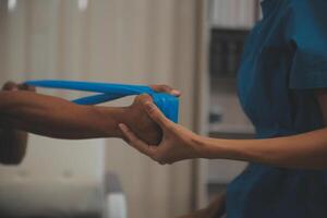 Professional physical therapist examines and cares for a young man in a physical therapy center, treating muscles and injuries of a man in a hospital. photo