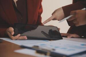 Group of confident business people point to graphs and charts to analyze market data, balance sheet, account, net profit to plan new sales strategies to increase production capacity. photo