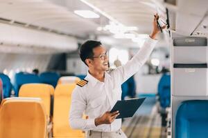 Portrait of a trained airplane captain in uniform preparing to fly in a simulator cockpit. photo
