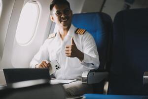 Portrait of a trained airplane captain in uniform preparing to fly in a simulator cockpit. photo
