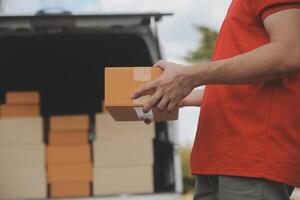 Asian delivery express courier young man use giving boxes to woman customer he wearing protective face mask at front home photo