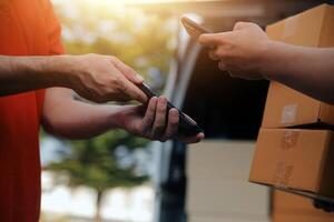 Asian delivery express courier young man use giving boxes to woman customer he wearing protective face mask at front home photo