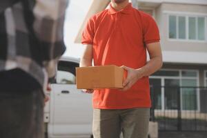 Asian delivery express courier young man use giving boxes to woman customer he wearing protective face mask at front home photo