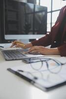Cropped image of professional businesswoman working at her office via laptop, young female manager using portable computer device while sitting at modern loft, flare light, work process concept photo