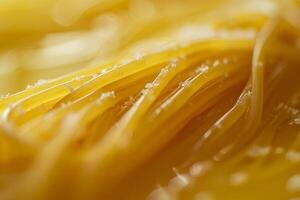 Close up of uncooked spaghetti pasta on yellow background photo