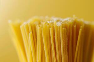 Close up of uncooked spaghetti pasta on yellow background. Selective focus. photo