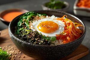 Bibimbap with rice, vegetables and egg in bowl photo